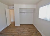 Thumbnail 8 of 20 - A room with a wooden floor and white walls.
