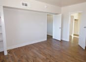 Thumbnail 5 of 20 - A room with white walls and wooden flooring.