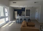 Thumbnail 5 of 20 - A kitchen with a refrigerator, microwave, and oven is visible.