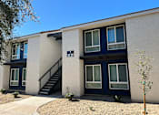 Thumbnail 1 of 20 - A building with a blue door and windows with white curtains.