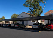 Thumbnail 6 of 20 - A parking lot with cars parked under a covered area.