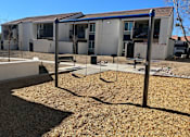 Thumbnail 9 of 20 - A playground with a swing set in front of a building.