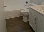 Thumbnail 18 of 20 - A white toilet sits in a bathroom next to a sink.