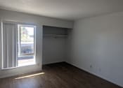 Thumbnail 20 of 20 - Empty room with a window and wooden floor.