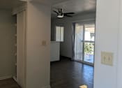 Thumbnail 15 of 20 - A room with a ceiling fan and wooden flooring.