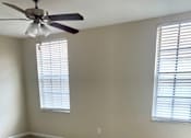 Thumbnail 8 of 16 - an empty room with a ceiling fan and two windows