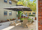 Thumbnail 26 of 32 - a patio with a table and chairs in front of a building