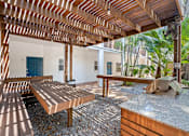 Thumbnail 24 of 30 - a covered patio with a picnic table and grill