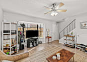Thumbnail 3 of 14 - a living room with a ceiling fan and a tv