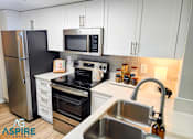 Thumbnail 28 of 56 - A kitchen with white cabinets and a stainless steel refrigerator.