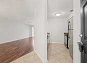Thumbnail 5 of 16 - A kitchen with a black door is visible.