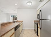 Thumbnail 6 of 16 - A kitchen with a black fridge and a black dishwasher.