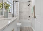 Thumbnail 21 of 22 - a bathroom with a white sink and toilet and a white bathtub with a shower curtain and