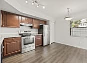 Thumbnail 2 of 16 - A kitchen with wooden cabinets and stainless steel appliances.