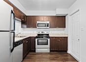 Thumbnail 9 of 32 - a kitchen with dark wood cabinets and stainless steel appliances