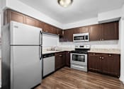 Thumbnail 3 of 32 - a kitchen with dark wood cabinets and stainless steel appliances