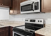 Thumbnail 6 of 32 - a kitchen with mahogany cabinets and a black and white stove top oven