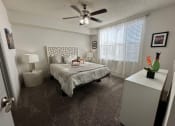 Thumbnail 9 of 46 - a bedroom with a bed and a ceiling fan