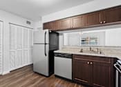 Thumbnail 4 of 32 - a kitchen with dark wood cabinets and white appliances