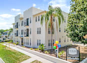Thumbnail 1 of 22 - a white building with palm trees in front of it