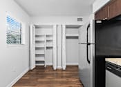 Thumbnail 11 of 32 - a small kitchen with white walls and wood flooring