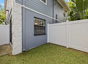 Thumbnail 15 of 16 - A grey house with a white fence and a small garden.
