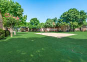 Thumbnail 46 of 47 - a volleyball court in the middle of a lush green park