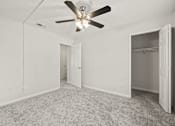 Thumbnail 12 of 16 - A room with a ceiling fan and carpeted floor.