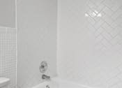 Thumbnail 23 of 32 - a bathroom with a white tub and a white toilet