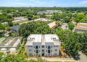 Thumbnail 5 of 22 - an aerial view of a large white building with a pool in front of it