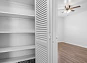 Thumbnail 13 of 32 - a bedroom with a closet and a ceiling fan