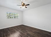 Thumbnail 15 of 32 - a bedroom with hardwood floors and a ceiling fan