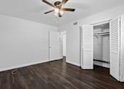 Thumbnail 20 of 32 - a bedroom with hardwood floors and a ceiling fan