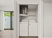Thumbnail 11 of 16 - A white laundry room with a washer and dryer in a cabinet.