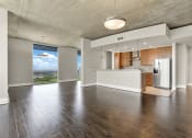 Thumbnail 114 of 114 - Empty living room with kitchen and large window offering city views in Houston, TX