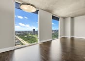 Thumbnail 113 of 114 - Empty living room with panoramic city views through large windows in Houston, TX