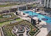 Thumbnail 10 of 114 - Aerial view of the pool courtyard surrounded by greenery and lounge areas in Houston, TX.