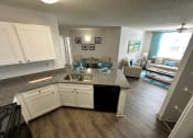 Thumbnail 6 of 46 - an open kitchen and living room with a table and a couch