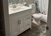 Thumbnail 74 of 75 - A white bathroom with a sink, toilet, and shower.