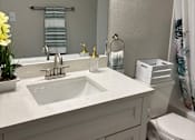 Thumbnail 73 of 75 - A white bathroom with a sink, toilet, and a mirror.