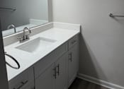 Thumbnail 71 of 75 - A bathroom with a white counter top and a round sink.