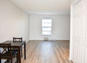 Thumbnail 14 of 28 - A room with a wooden floor and a table with chairs.