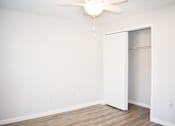 Thumbnail 27 of 28 - A white room with a ceiling fan and a white closet.