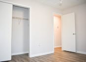 Thumbnail 26 of 28 - A white door is open to a room with a wooden floor.