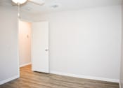Thumbnail 25 of 28 - A room with a white door and wooden floor.