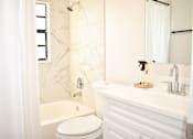 Thumbnail 22 of 28 - A white bathroom with a toilet, sink, and bathtub.