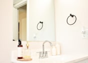 Thumbnail 20 of 28 - A bathroom with a white sink and a mirror above it.