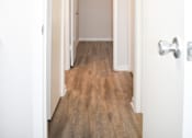Thumbnail 23 of 28 - A hallway with a wooden floor and white walls.