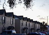 Thumbnail 5 of 28 - A row of houses with cars parked in front.