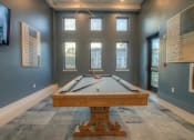 Thumbnail 14 of 40 - a pool table in a room with windows